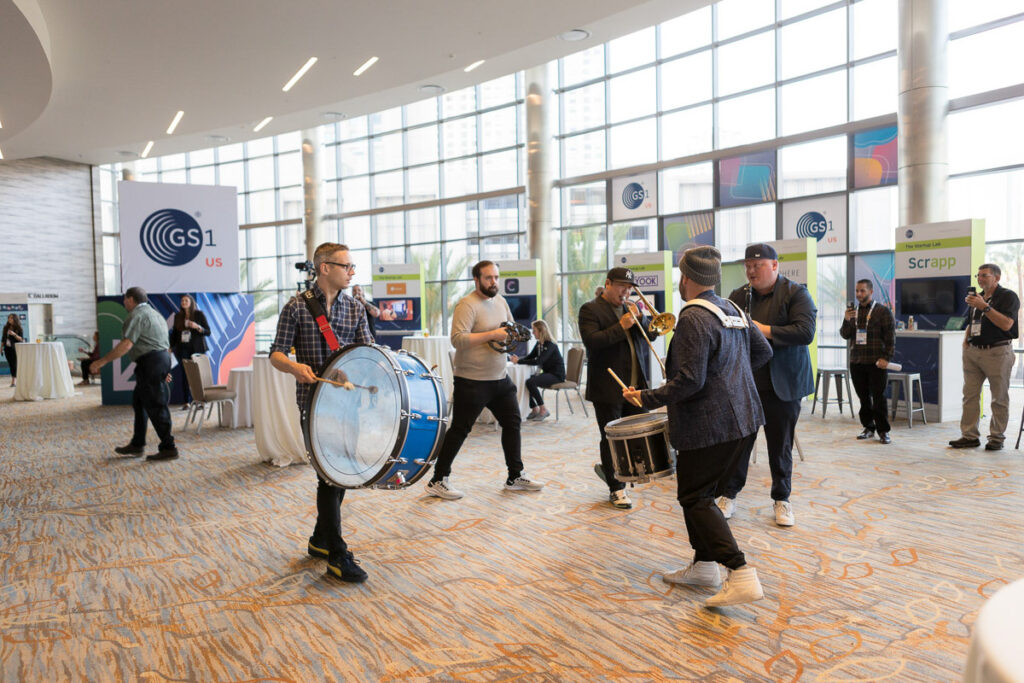 A lively band of musicians adds a festive atmosphere to the conference hall with their enthusiastic performance.