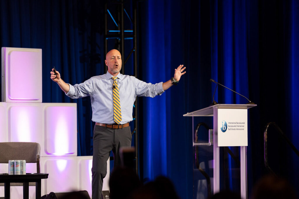 A confident speaker engages the audience during a keynote presentation at a professional conference.