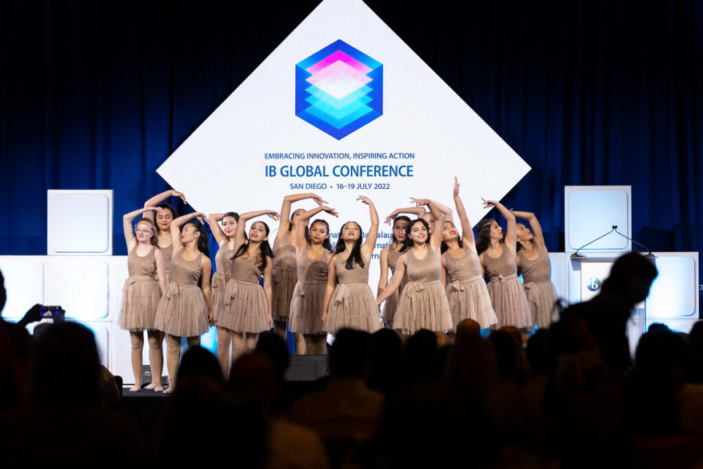 Performers on stage at an event with the backdrop reading "ib global conference - embracing innovation, inspiring action - san diego - 14-17 july 2022".