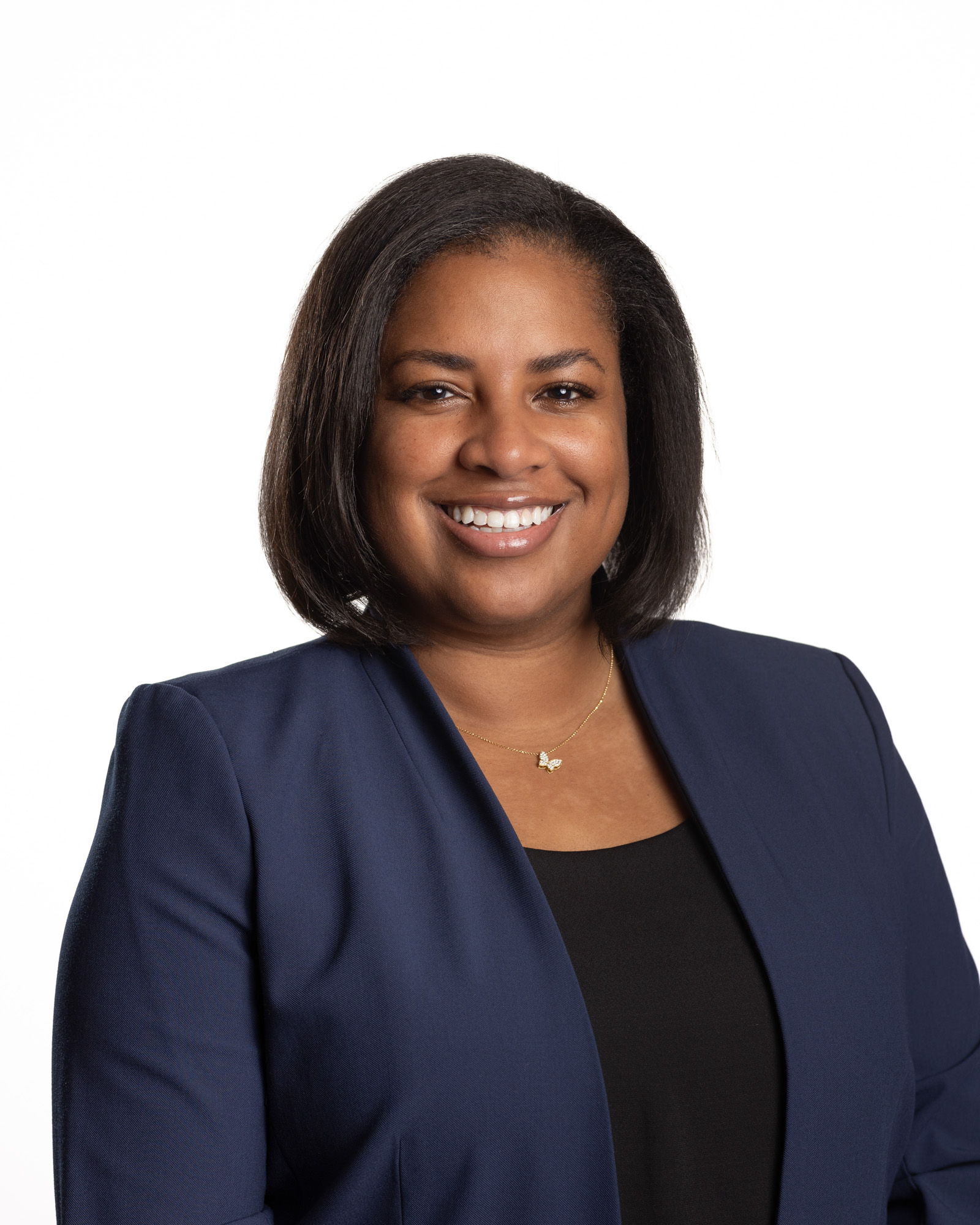 A professional portrait of a smiling woman wearing a blue blazer, projecting confidence and approachability.