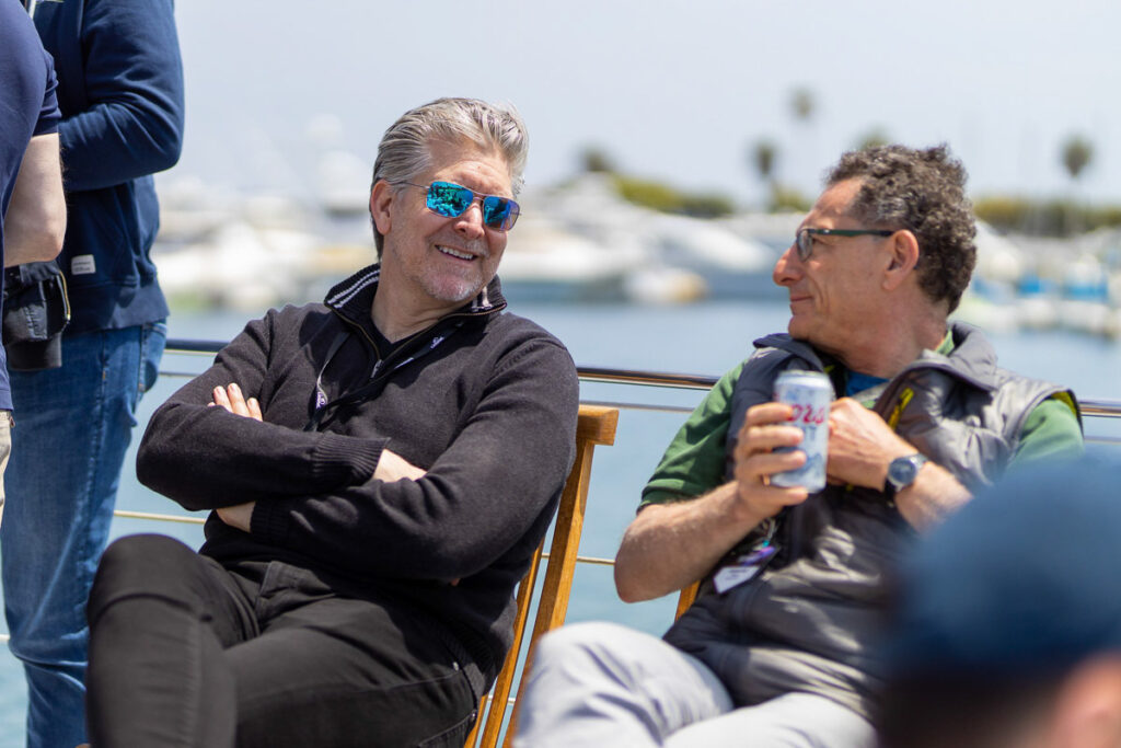 Two men relaxing and enjoying a conversation on a sunny day by the marina.